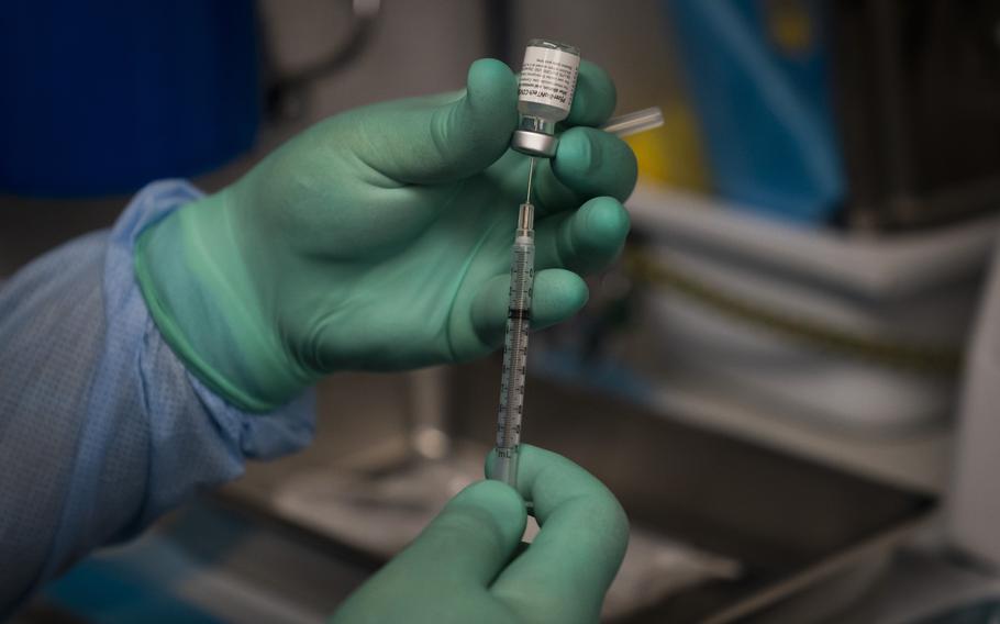 Parsia Jahanbani prepares a syringe with the Pfizer COVID-19 vaccine in a mobile vaccine clinic operated by Families Together of Orange County in Santa Ana, Calif., in August 2021. An international group of scientists is arguing the average person doesn't need a COVID-19 booster yet — an opinion that highlights the intense scientific divide over the question.