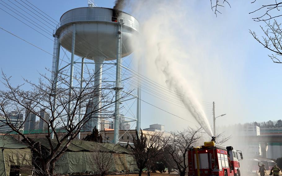 Firefighters battle a blaze caused by a South Korean drone that struck a water tower at the U.S. Army's Busan Storage Center in Busan South Korea, Thursday, March 3, 2022.