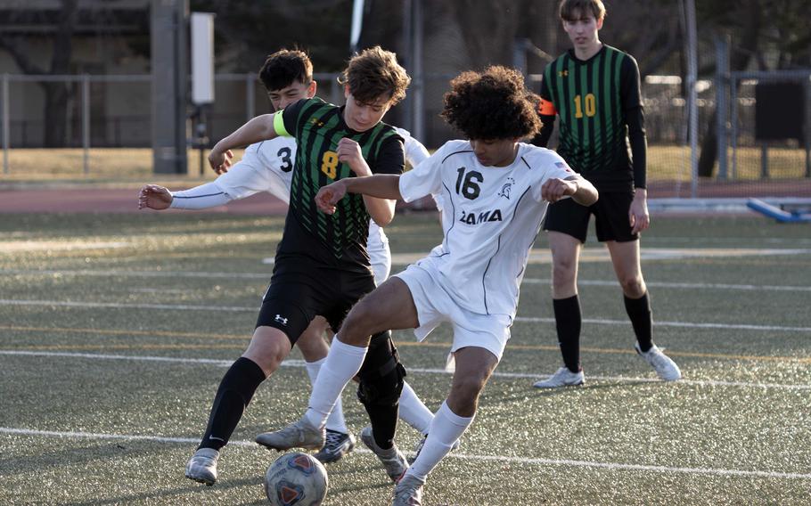 Robert D. Edgren’s Santi Castano and Zama’s Chris Jones and Roman Romero chase the ball during Friday’s DODEA-Japan boys soccer match. The Trojans won 3-0.