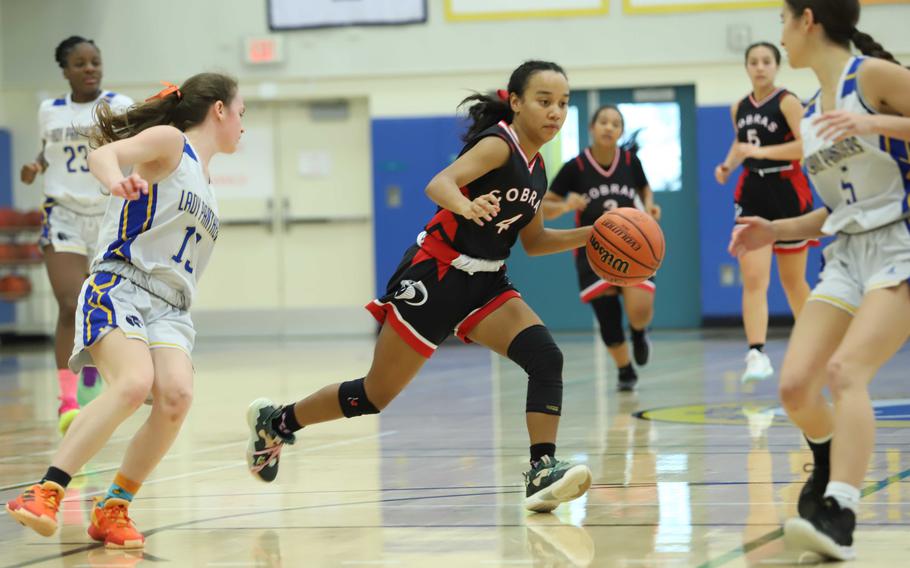 King's Moa Best dribbles between Yokota defenders Hailey Riddels and Erica Haas. The Cobras won 48-30.