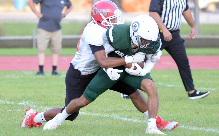 Nile C. Kinnick's Devin Jackson drags down Kubasaki receiver Justin Murray.