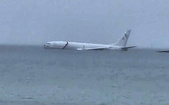This photo provided by Diane Dircks shows a U.S. Navy plane that overshot a Marine base on Kaneohe Bay, Hawaii, Monday, Nov. 20, 2023. An official says all nine people aboard the plane have escaped injury. (Diane Dircks via AP)
