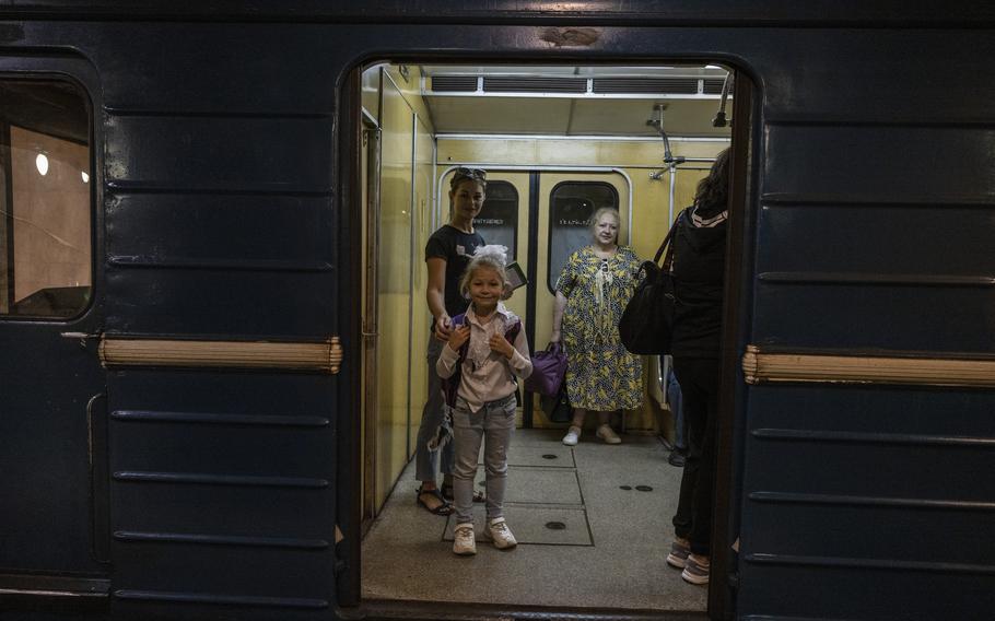 Ira Kravchenko, 36, and her daughter Nicole, 6, wait on a train after the first day of classes held in the underground metro station in Kharkiv, Ukraine.