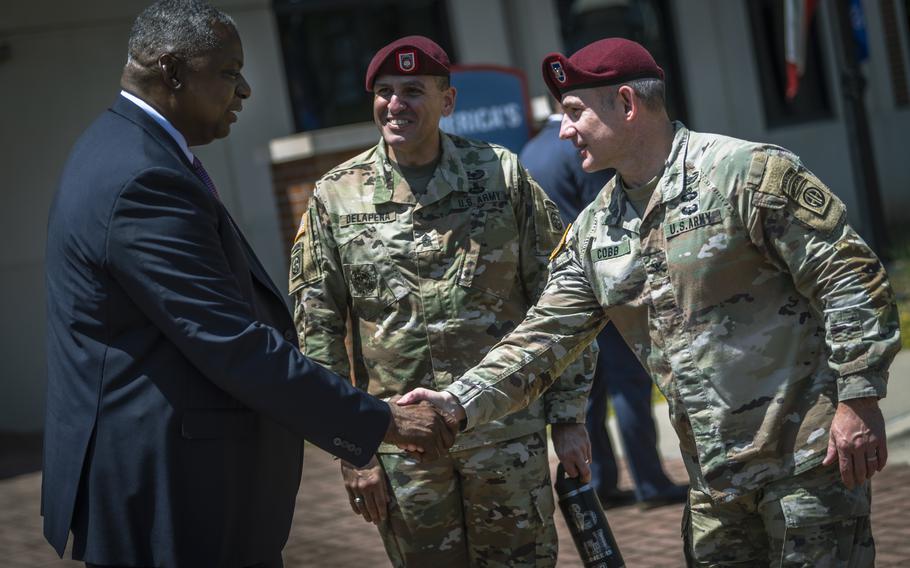 Defense Secretary Lloyd Austin is greeted by Col. Adam Cobb, 82nd Airborne Division chief of staff, and Command Sgt. Maj. Randolph Delapena on May 12, 2023, during a visit to Fort Bragg, N.C.