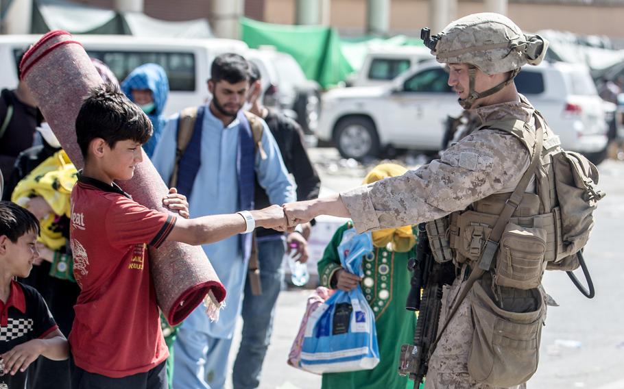 A U.S. Marine greets a child being evacuated out of Hamid Karzai International Airport in Kabul, Afghanistan, Aug. 24, 2021. 