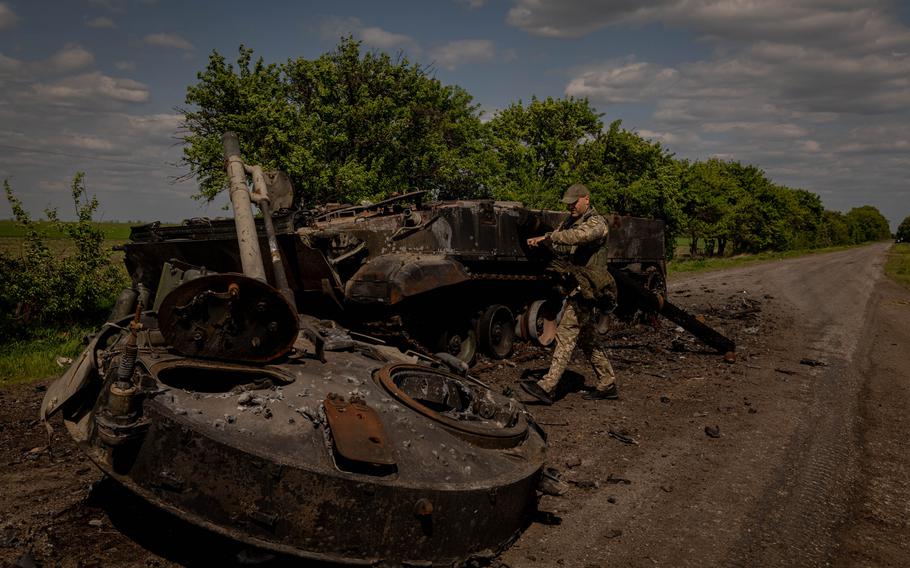 A Ukrainian serviceman is seen inspecting the remains of a destroyed Russian infantry fighting vehicle on a road near the frontline in Zaporizhzhia Oblast, Ukraine, on Wednesday, May 11, 2022. 