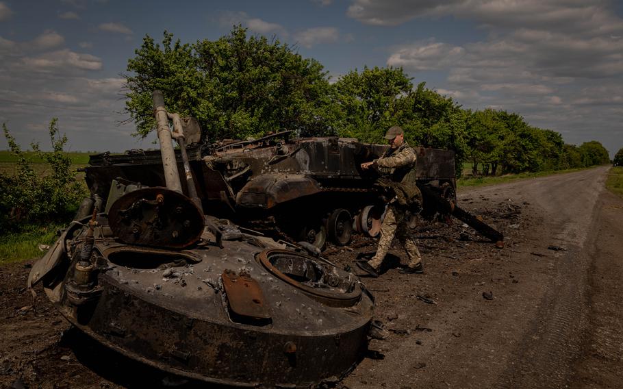 A Ukrainian serviceman is seen inspecting the remains of a destroyed Russian infantry fighting vehicle on a road near the frontline in Zaporizhzhia Oblast, Ukraine, on Wednesday, May 11, 2022. 
