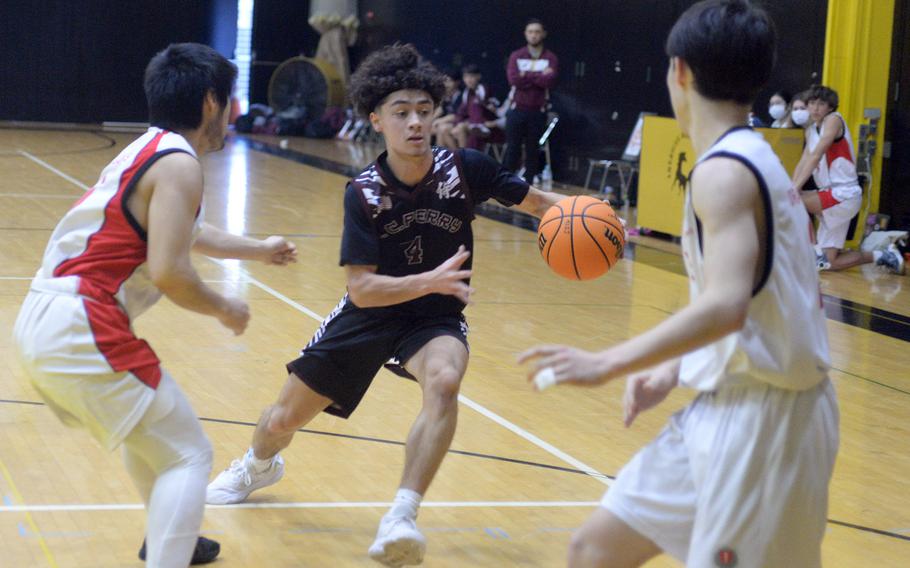 Matthew C. Perry's Tyler Gaines looks to weave between Yokohama International defenders during Friday's 5th American School In Japan Kanto Classic boys knockout game. The Dragons won 46-43.