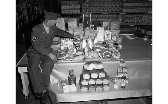 American-occupied zone of Germany, Sep. 1947: An unidentified Staff Sergeant of the Fourth Air Force of the U.S. Air Force shows the food rations for one U.S. servicemember stationed in Germany. The photograph - with a list of the exact month ration's quantities - ran in the Weekend section of the European Stars and Stripes on October 4th, 1947. It illustrated an article explaining to the apparently grumbling dependent wives of servicemembers why the shelves of the commissary don't seem to hold what they want and the produce and eggs are not always fresh. With food production and food distribution in civilian Germany still suffering from years of war, food for the servicemember - and the ever increasing number of dependents that arriveds - had to be shipped from the United States. The original caption noted that the alloted 3,700 calories per day, per servicemember day cost the Army approximately ninety-five cents. 

Looking for Stars and Stripes’ historic coverage? Subscribe to Stars and Stripes’ historic newspaper archive! We have digitized our 1948-1999 European and Pacific editions, as well as several of our WWII editions and made them available online through https://starsandstripes.newspaperarchive.com/

META TAGS: Quartermaster Corps; QM; food distribution; Cold War; post-war; Kraft; Jell-O; Kellog's; Nabisco; Gold Medal Flour; Karo syrup; Wheaties; Post's Grape Nuts; Cornflakes; Lipton; warehouse; 4th Air Force; U.S. Air Force