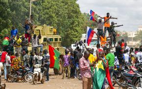 Supporters of Capt. Ibrahim Traore cheer with Russian flags in the streets of Ouagadougou, Burkina Faso, Sunday, Oct. 2, 2022. Burkina Faso's new junta leadership is calling for calm after the French Embassy and other buildings were attacked. (AP Photo/Kilaye Bationo)