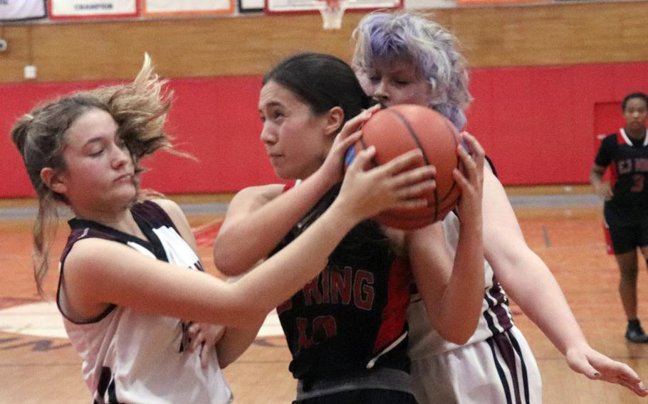 E.J. King's Maliwan Schinker tries to play keepaway with Zama's Juliet Bitor and Kaitlynn McAbee during Saturday's DODEA-Japan girls basketball game. The Cobras won 70-36.