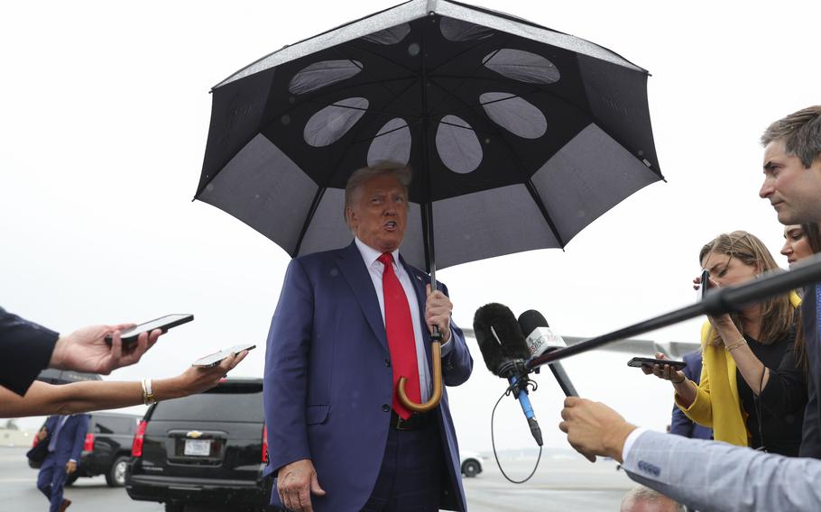 Former president Donald Trump speaks to journalists Thursday at Reagan National Airport in Arlington, Va.