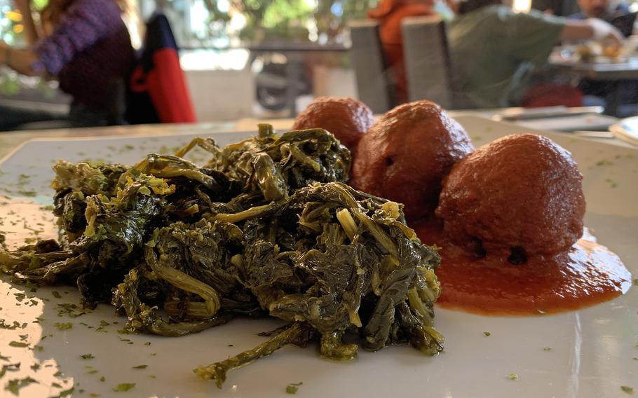 Second courses at Cavoli Nostri in Naples, Italy, include legume balls with a rich tomato sauce and friarielli.