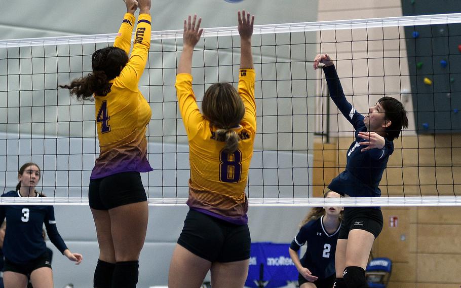 Black Forest Academy's Diaz Gonzalez Lynnea, right, spikes the ball while, from left, Bahrain's Jillian Brown and Gabriella Vargas go for the block during pool play on Thursday at Ramstein High School at Ramstein Air Base, Germany.

Matt Wagner/Stars and Stripes