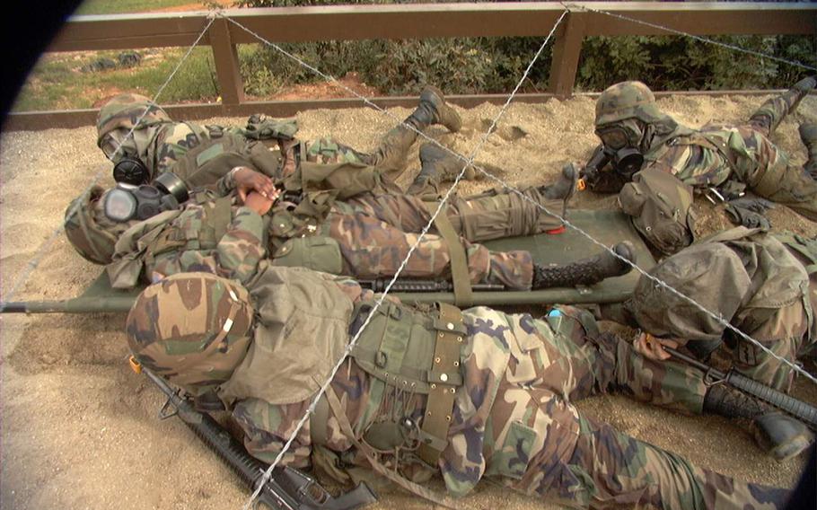 Four soldiers crawl prone.