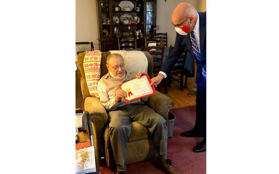 After a chilly ceremony outside, François  Kloc, right, honorary consul of France in Jacksonville, and Earl Mills of Live Oak went inside to pose with a certificate that goes along with the Chevalier de la Légion d’Honneur, the highest French distinction for military and civil accomplishments. Mills, 100, was a U.S. paratrooper who took part in the liberation of Europe during World War II.