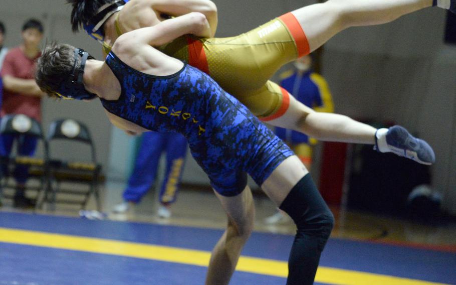 Yokota's Tate Rannow sends St. Mary's Taiyo Matsuoka airborne at 148 pounds during Wednesday's Kanto Plain wrestling dual meet. Rannow pinned Matsuoka in 3 minutes, 47 seconds, but the Titans won the meet 46-5.