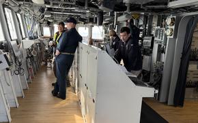 Crew members work aboard a ship.