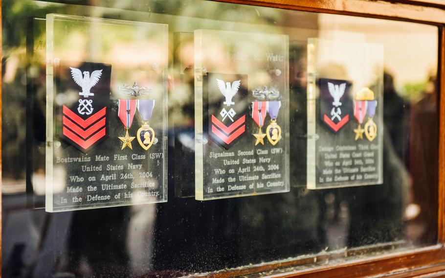 Sailors are reflected in a memorial that honors the sacrifices of three service members. Coast Guard Petty Officer 3rd Class Nathan Bruckenthal, Navy Petty Officer 1st Class Michael Pernaselli and Navy Petty Officer 2nd Class Christopher Watts were killed in a 2004 attack during a routine patrol in the Persian Gulf.