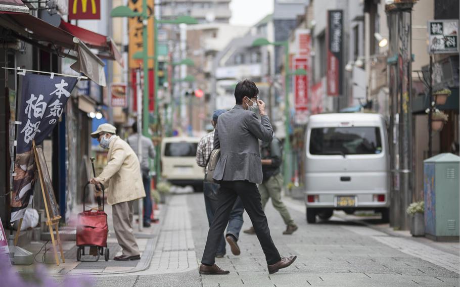 People walking near Tsunashima Station wear masks to prevent coronavirus infection earlier this spring in Yokohama, Japan.