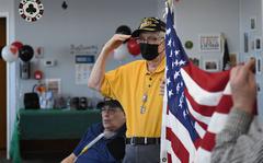 Harold Slate salutes during the singing of God Bless America to start the day at Silver Foxes Social Club in Baldwinsville in 2020.  Dennis Nett | dnett@syracuse.com
