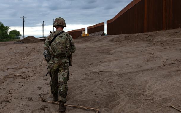 A National Guard soldier patrols along the wall at the southern border.