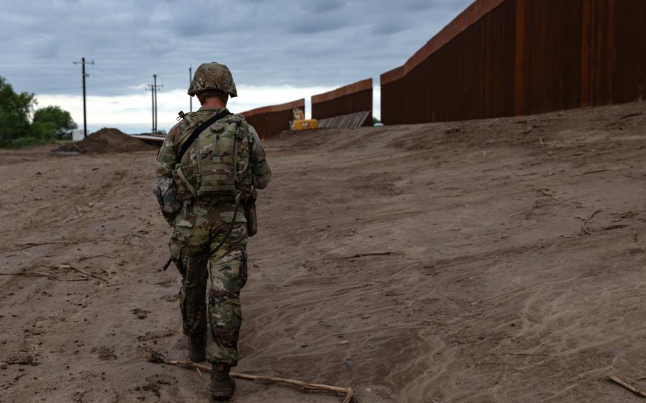 A National Guard soldier patrols along the wall at the southern border.