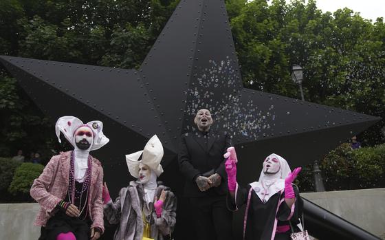 French artist Jean-Luc Verna, center, poses with performers during the inauguration of his sculpture, a memorial to the long-ignored gay victims of the Nazi regime and to all LGBTQ+ people persecuted throughout history, in Paris, Saturday, May 17, 2025. (AP Photo/Christophe Ena)