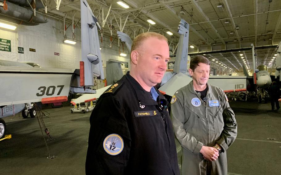 Rear Adm. D.J. Patchell, vice commander of U.S. 2nd Fleet, left, and Rear Adm. Gregory Huffman, commander of Carrier Strike Group 12, speak with reporters in the hangar bay of the USS Gerald R. Ford on Nov. 13, 2022.