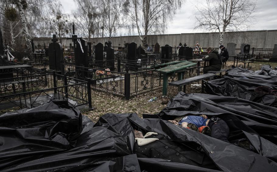 Police officers investigate on April 6, 2022. the killings of civilians in Bucha. 