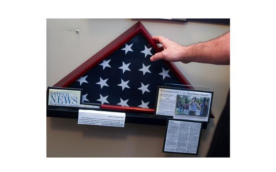 President and founder of Delta Veterans Group, J.R. Wilson touches the display case of an American flag at The Antioch Historical Museum on Wednesday, Feb. 21, 2024, in Antioch, Calif. The flag was given to the museum by veteran Michael Thomas Greenawalt, who claimed he was one of the last service members to leave Vietnam and donated the flag he carried out.  An investigation into Greenawalt’s military records show that he served as an army clerk in Germany and was not stationed in Vietnam.  