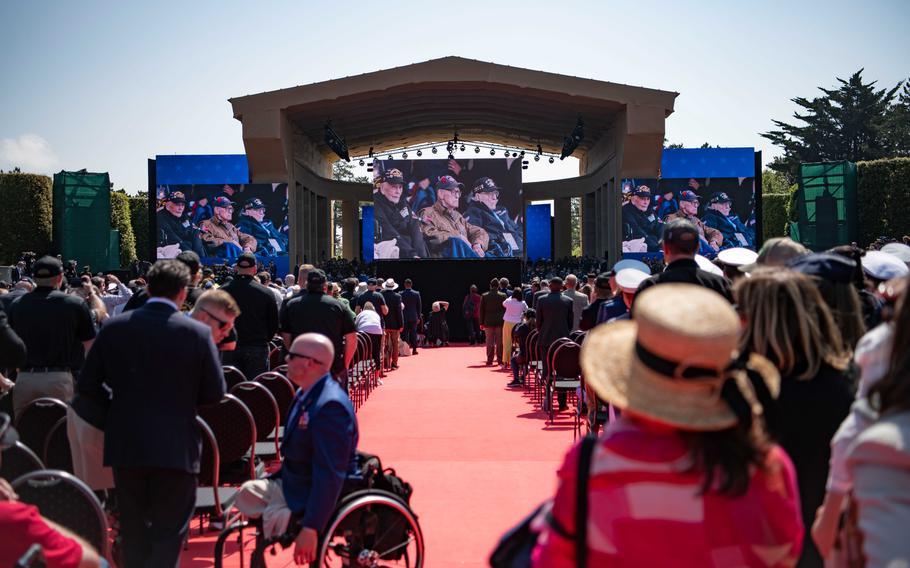 People look on as World War II veterans are escorted into a ceremony at Normandy American Cemetery in Colleville-sur-Mer, France, to commemorate the 80th anniversary of D-Day. 