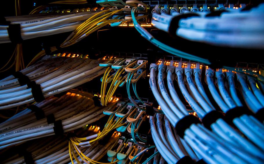 Fiber optic cables, center, and copper Ethernet cables feed into switches inside a communications room at an office in London on May 21, 2018.