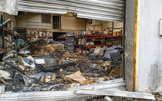 The interior of a warehouse is seen strewn with wreckage.