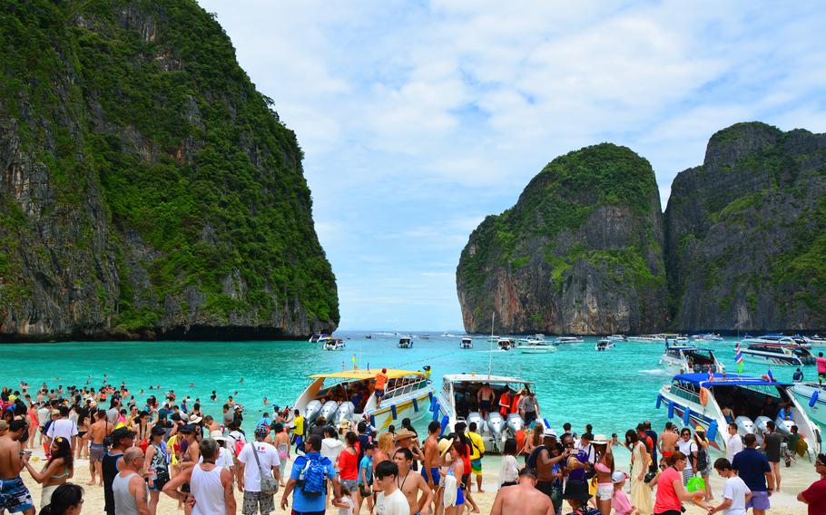 Maya Bay, a Thai beach made famous by the movie “The Beach,” will reopen in January after a more than three-year closure so the site and coral reef could recover from overuse. Above: Crowds flock to the sand and waters in 2015. 