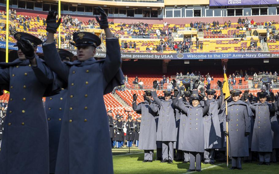 Cadets raise their hands in their during a cheer routine.