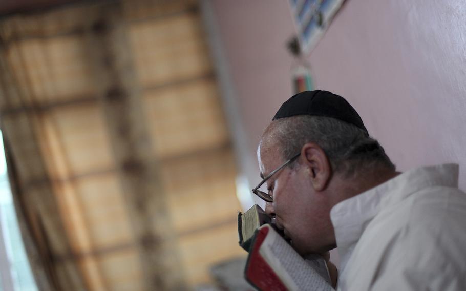 Zebulon Simentov, the last known Jew living in Afghanistan and the caretaker and sole member of Afghanistan’s only working synagogue kisses his prayer book while observing Shabbat in his Kabul home onAug. 29, 2009. Simentov who prayed in Hebrew, endured decades of war as the country’s centuries-old Jewish community rapidly dwindled has left the country.