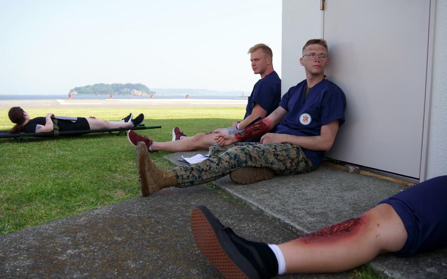 Actors taking part in an earthquake-response drill wait to be evacuated by helicopter at Yokosuka Naval Base, Japan, Thursday, May 18, 2023.