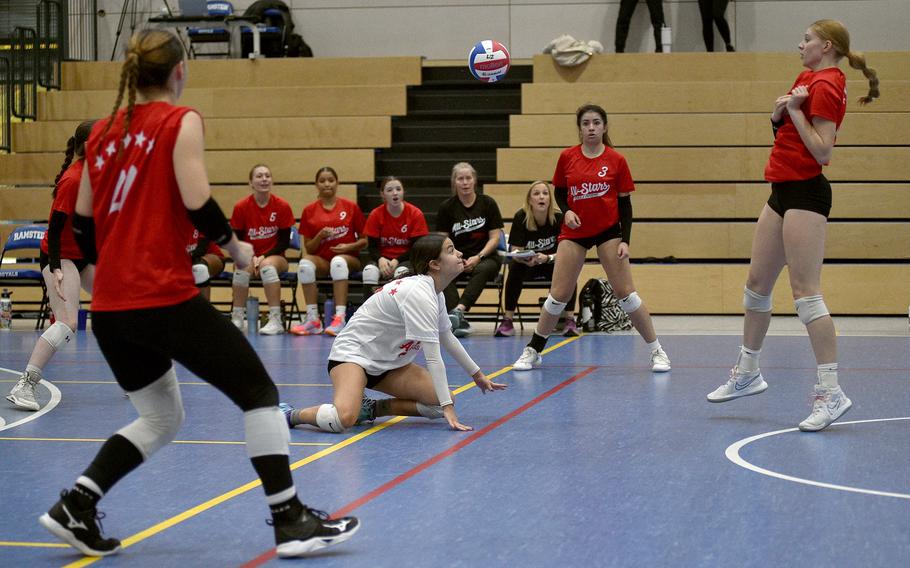 Red Team libero Marisa Branch watches the ball sail over her head after being touched by teammate Addison Krajicek of Aviano, right, during a DODEA-Europe all-star volleyball match on Nov. 4, 2023, at Ramstein High School on Ramstein Air Base, Germany.