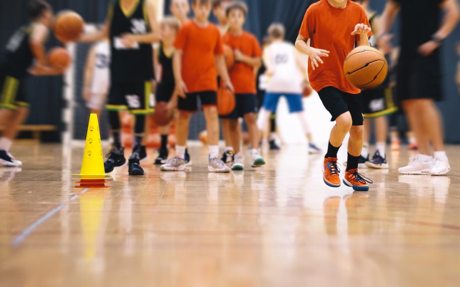  Kids play sports during a basketball training drills on a wooden court