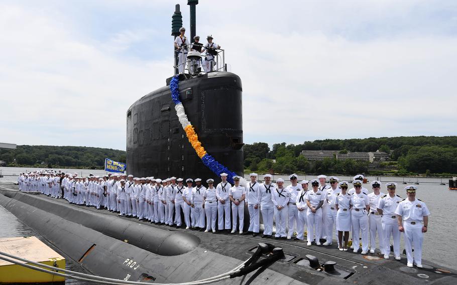 Sailors gather top-side of a submarine