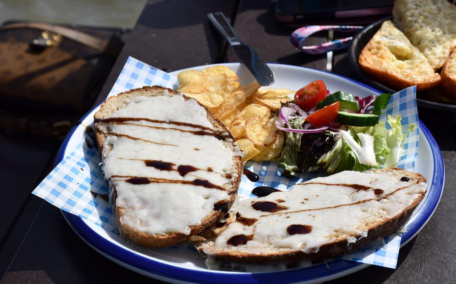 An open-face sandwich with a side salad and potato chips waits to be eaten at the Boardwalk Cafe Bar on the Felixstowe Pier in Felixstowe, England.