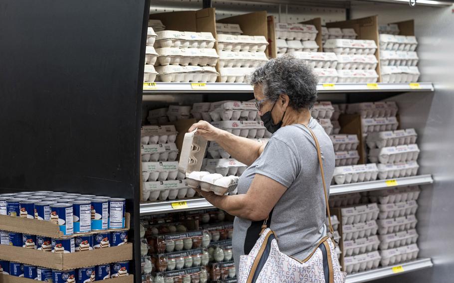 A shopper checks a carton of eggs inside a grocery store in San Francisco, Calif., on May 2, 2022. Easing inflation and mended supply chains are translating into more buying power for Americans despite a softer labor market.