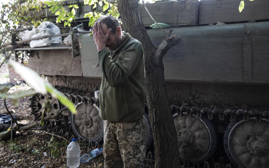 A Ukrainian soldier rests by a military vehicle in a liberated village in the Kherson region in October 2022.