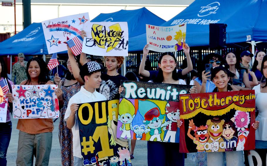 Friends and family hold up signs