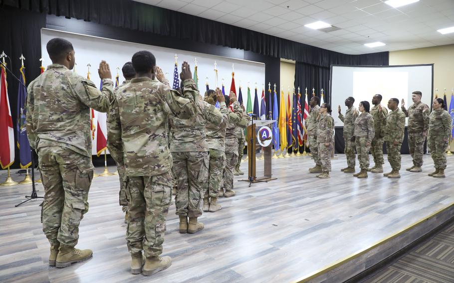 Soldiers take an oath of service during a mass re-enlistment at Camp Arifjan, Kuwait, Wednesday, June 14, 2023. 