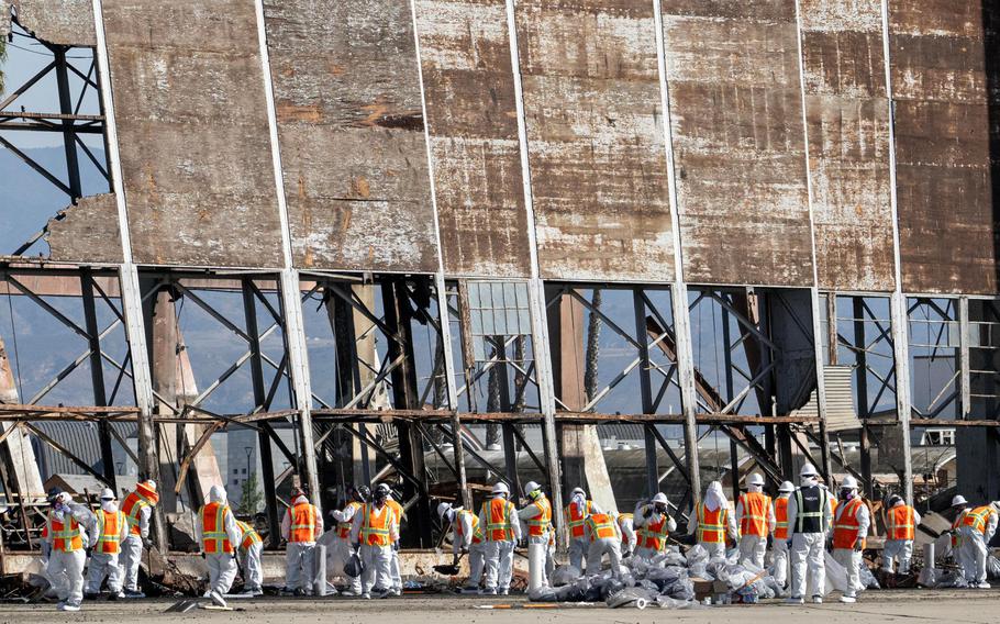 Workers in protective gear take part in hazardous waste clean up on Sunday, December 3, 2023 at the historic Marine Corps Air Station in Tustin. The hangar was destroyed in a fire last month.