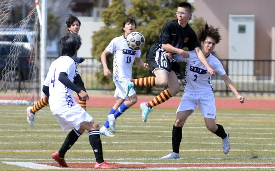Perry's Anthony Salas goes up to play the ball between two Senri Osaka International defenders during Saturday's Perry Cup semifinal, won by the Samurai in penalties.