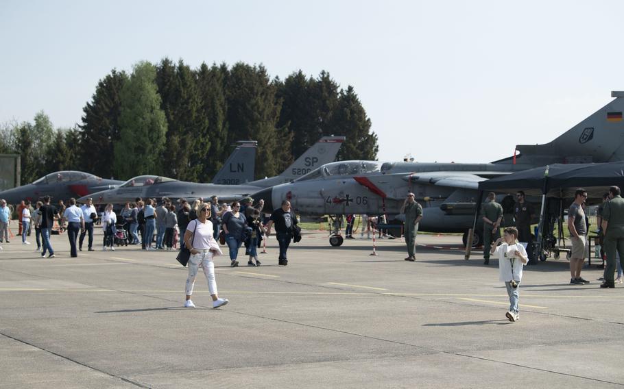 Visitors to a family day event walk past a German air force Tornado, a U.S. Air Force F-16 Fighting Falcon, and a U.S. Air Force F-15 Eagle at Buechel Air Base, Germany, May 7, 2022. A recent survey by the German news service ARD showed a majority of respondents support maintaining U.S. nuclear weapons in Germany, some of which are believed to be stored at Buechel.