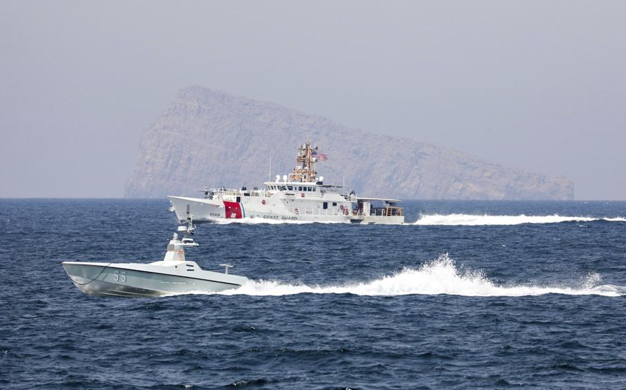 A U.S. Navy L3 Harris Arabian Fox MAST-13 drone boat and the U.S. Coast Guard cutter USCGC John Scheuerman transit the Strait of Hormuz on Wednesday, April 19, 2023.